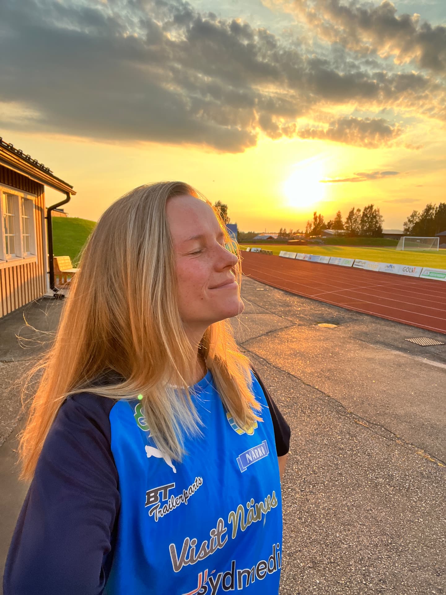 Alexandra blundar mot solnedgången vid en fotbollsplan efter träning