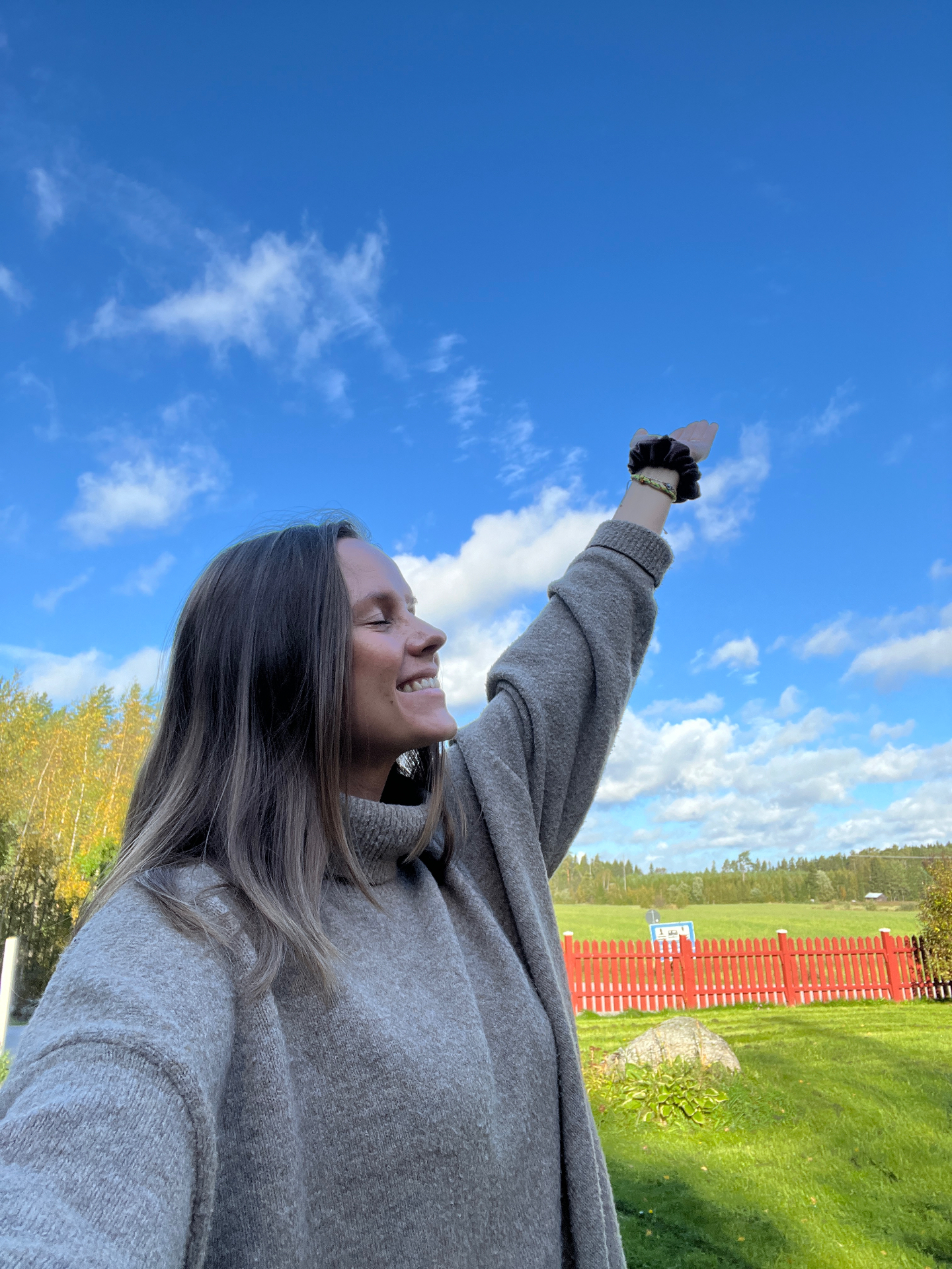 Alexandra sträcker armen mot himlen — öppenhet och nya möjligheter